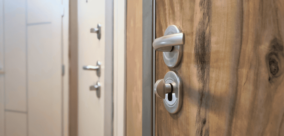 Maniglia e serratura di una porta blindata con pannello interno effetto legno naturale, in esposizione showroom