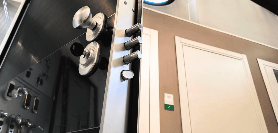 Dettaglio di porta blindata nera lucida con maniglia e cilindro di sicurezza con i pistoni aperti